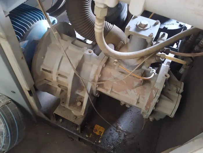 Unidade compressora de parafuso desmontada na bancada para revisão